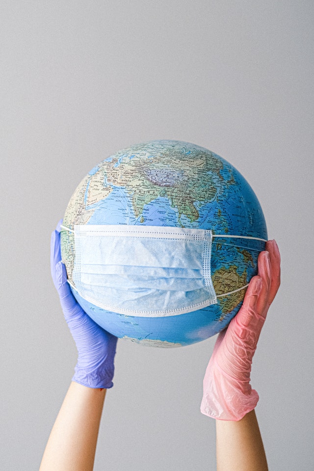 hands-with-latex-gloves-holding-a-globe-with-a-face-mask-4167544-1